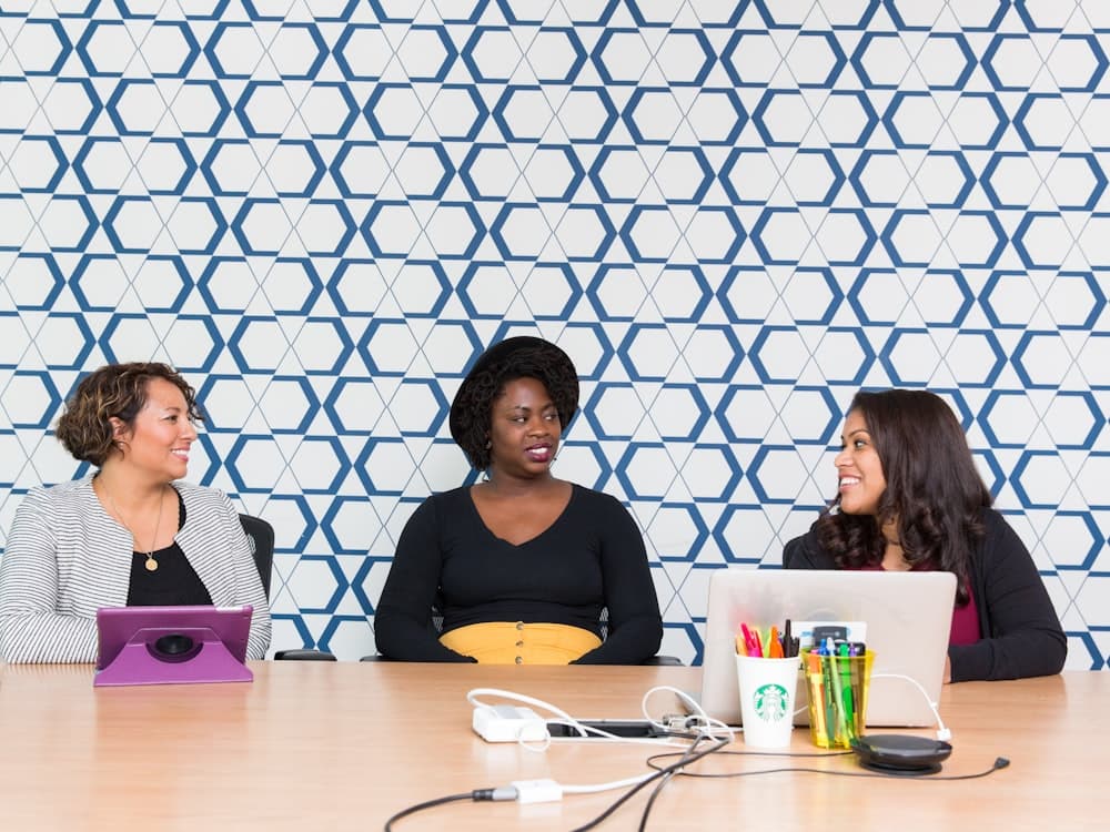 Team members sharing a lighter moment over a laptop